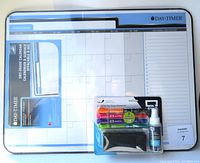 White Day-Timer dry erase monthly calendar board with included markers, spray cleaner, and eraser in original packaging.