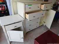 White tall dresser and end table with drawers and cabinet doors open showing interior condition.
