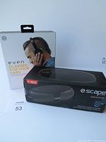 Photo showing both products boxed: Even H4 headphones and Escape Platinum wireless speaker.