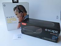 Display of even H4 headphones box with front image showing man wearing headphones; Escape Platinum wireless stereo speaker box also displayed