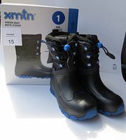 Pair of black xmtn kids winter boots size 1 displayed with original box showing brand and size.
