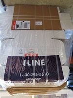 Top view of bundled white mailer boxes wrapped in plastic with ULINE label visible