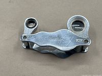 Folded vintage Corton combo loupe showing the two integrated magnifying lenses labeled 15x and 10x power with chrome metal body.