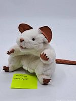 White mouse hand puppet with brown details and fabric lining tag.