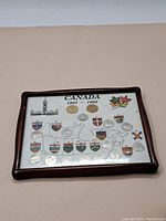 Full view of wood-framed set showing multiple Canadian commemorative coins, map of Canada, provincial shields, and maple leaf graphics on white backing.