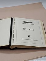 Album open to title page showing 'Schaubek Stamp Album Canada'