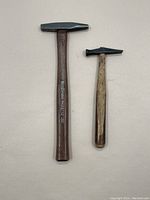 Two small hammers side by side, showing full handles and hammer heads.