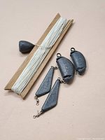 Photo showing all fishing weights and fishing line on wooden card.