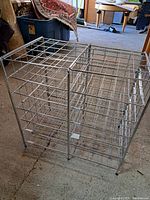 Side view of a steel wire shelving unit with multiple grid compartments, showing structural details and surface condition.