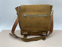 Front view of vintage leather satchel bag showing the flap with zippered pocket and adjustable strap.