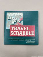 Top view of closed Travel Scrabble metal game box with teal color and vintage graphics.