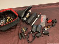 Full view of lot showing bike saddle, pump, pedals, lights, grips, mirror, chain links and pouch with accessories.