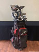 Front view of Callaway golf bag fully loaded with assorted golf clubs, showing the bag's color and external pockets