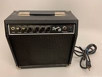 Front angle view of Fender Squire 15 amplifier showing control panel, knobs, input jack, and power switch.