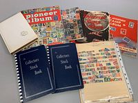 Photo showing six stamp albums and stock books arranged on a surface, displaying the variety of vintage albums included in the lot.