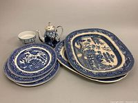 Porcelain teapot with blue designs and four blue and white plates and platters