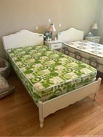 Full view of assembled bed frame with mattress and box spring in room.