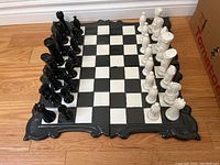 Ceramic chess board with black and white pieces arranged in starting position