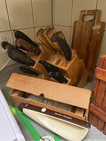 Photo showing wooden knife block with knives, Philips electric cutter in box, and wooden cutting boards in background.