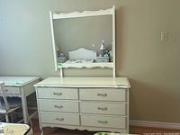 Front view of white six-drawer dresser with mirror