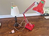 Both lamps placed on wooden floor showing lamp structure, shades, and cords