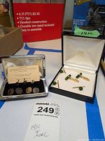 Two presentation boxes side by side showing Gump’s jade cufflinks and Swank evening set
