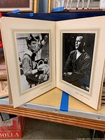 Two autographed photos of Tom and Dick Smothers mounted in mats with names printed below each photo, displayed open.