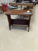 Front view of wooden bench showing flat top and lower shelf