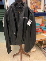 Full front view of black leather Harley-Davidson jacket on stand