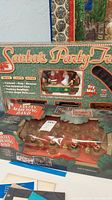 Santa's Party Train and Santa's Marching Band in original boxes with visible product names and features