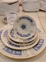 Single place setting stack: soup cup atop saucer, salad plate, dinner plate