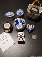 Photo showing all six miniature trinket/pill boxes including the Limoges 22k gold box and sterling silver boxes with a coin for size reference.