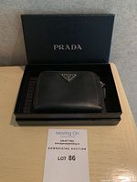 Wallet with original black Prada box and dust bag visible
