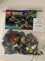 Bag of unassembled LEGO pieces with various colored pieces and wheels, includes instruction booklet for set 79102.