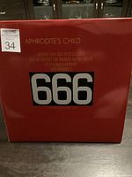 Red gatefold cover of Aphrodite's Child 666 album showing front artwork with large 666 and band name.