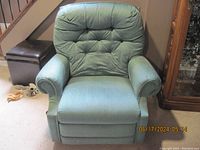 Front view of green tufted back fabric swivel recliner chair
