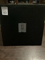 Front cover of the Joy Division Unknown Pleasures vinyl album showing black background with white pulsar waveform graphic.