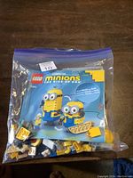 Plastic bag containing loose LEGO pieces and instruction booklet for Minions The Rise Of Gru Set 75551