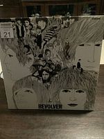 Front cover of The Beatles Revolver vinyl album with artistic and detailed black and white illustrations of the band members' faces and the album title.