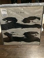 Front cover of the U2 Boy vinyl album showing white background with black distorted band member silhouettes and 'U2 Boy' title.
