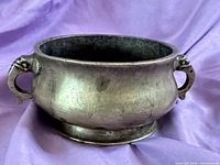 Overall side view of antique Chinese bronze censer showing rounded body and elephant ear handles.
