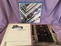 Three Beatles vinyl albums: 1967-1970 blue album, Love Songs Vol 1 with cream cover, and 1962-1966 red album partially visible.