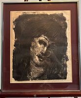 Framed portrait artwork showing a dark textured background with a woman's face, mounted in a dark red mat inside a gold frame.