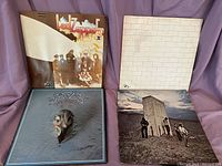 Four vinyl albums displayed stacked: Led Zeppelin II, Eagles, Pink Floyd The Wall, The Who Who's Next.