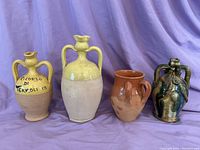 Four Italian ceramic vases and jars displayed against purple backdrop showing their size and style variations.
