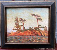 Framed lithograph/painting depicting a rocky island with pine trees in earthy tones, textured surface on board replicating original painting.
