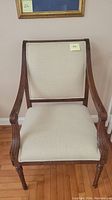 Front view of the beige fabric side chair showing the seat, backrest, and wooden frame.