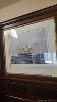 Framed limited edition artwork depicting the USS Constitution sailing at sea, showing detail of the ship and seascape in soft blue and gray tones.