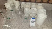 Overview of multiple Shannon crystal glasses, some wrapped in white tissue paper, displaying their clear cut crystal patterns and green Shannon Crystal labels.