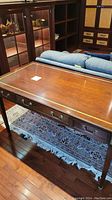 Front view of Stickley desk showing top surface, brass inlay, drawers and legs